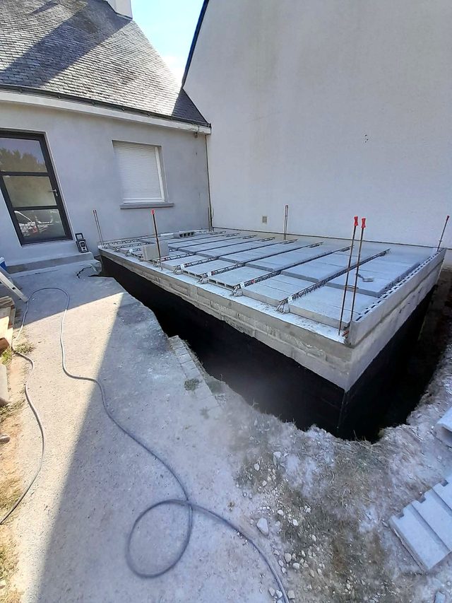 Murs du sous-sol étanchés par une membrane bitumineuse collée au chalumeau, poutrelles et hourdis posés pour le plancher de la chambre.