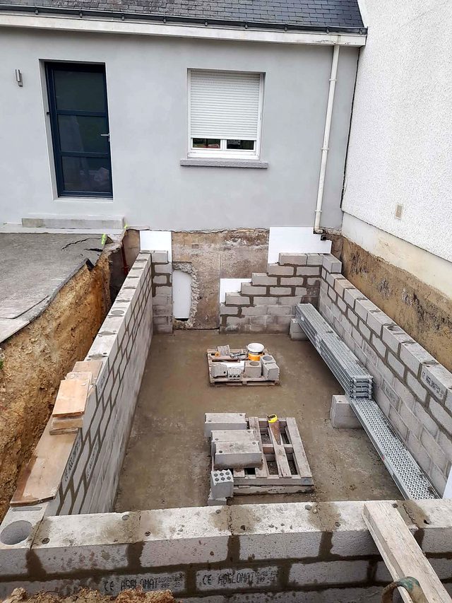 Dalle du sous-sol coulée, murs montés en parpaing.